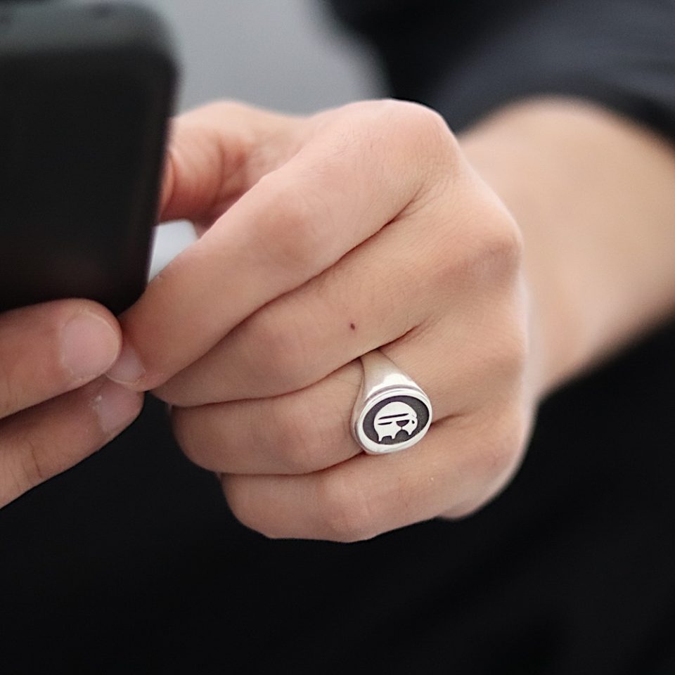 טבעת לגבר בצורת אליפסה עשויה מכסף ועם חריטה אישית ברקע שחור