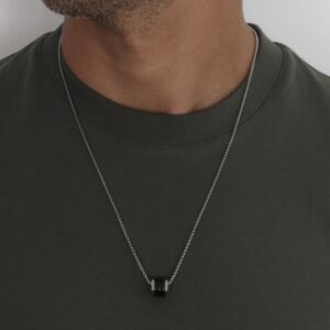 שרשרת נחש כסף לגבר עם תליון סליל שחור, על דוגמן בחולצה ירוקה